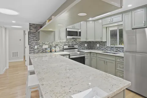 a kitchen with a sink stove and refrigerator