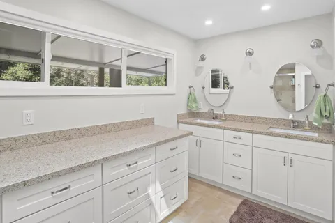 a spacious bathroom with double vanity and a mirror
