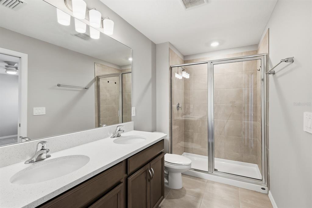 1782 Spreader Lane Sarasota, FL 34240 - Photo 17 of 38 a bathroom with a double vanity sink toilet and shower