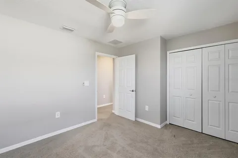 an empty room with a window and a fan