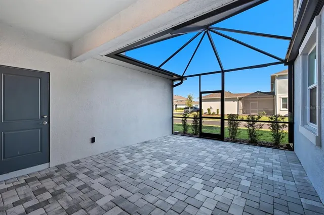a view of a sign board with flower plants and palm trees