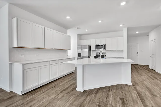 a kitchen with stainless steel appliances granite countertop a white stove top oven and a white cabinets