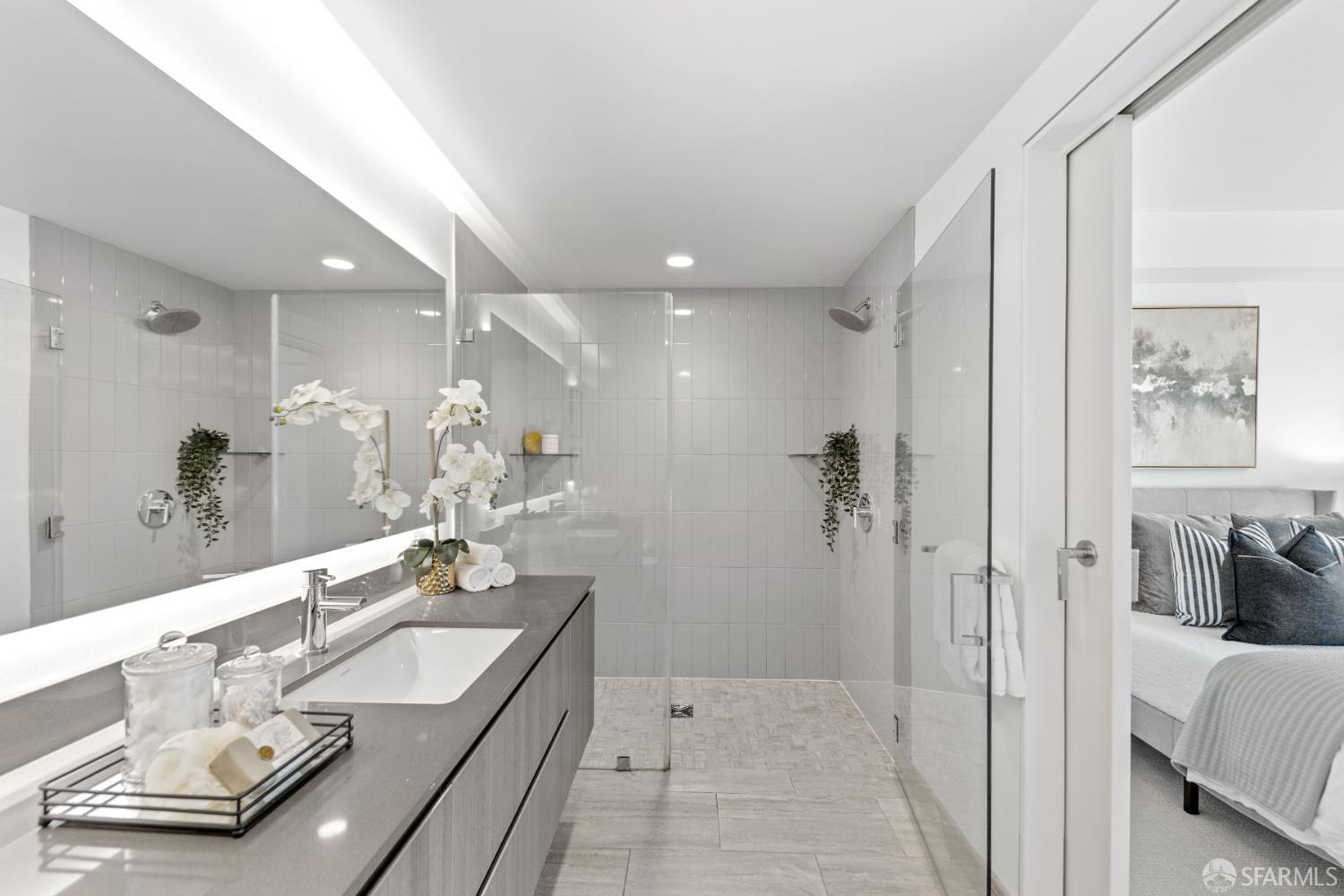 338 Potrero Avenue, Unit 206 San Francisco, CA 94103 - Photo 11 of 22 a bathroom with a granite countertop sink a mirror a vanity and shower