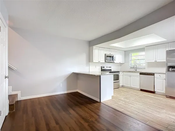 a kitchen with wooden floors and white appliances