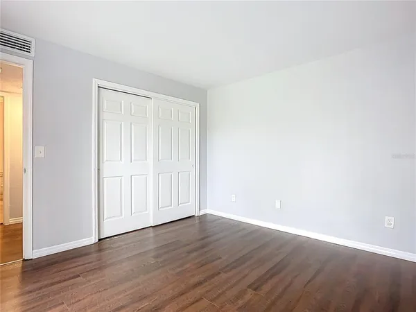 a view of an empty room with wooden floor