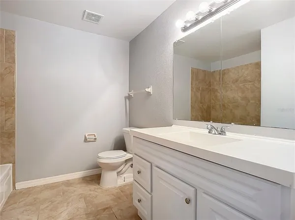 a bathroom with a toilet sink vanity and mirror