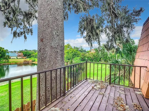 a view of a balcony with wooden floor and fence
