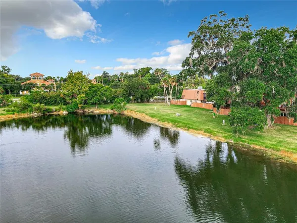 an aerial view of a house with outdoor space and trees all around