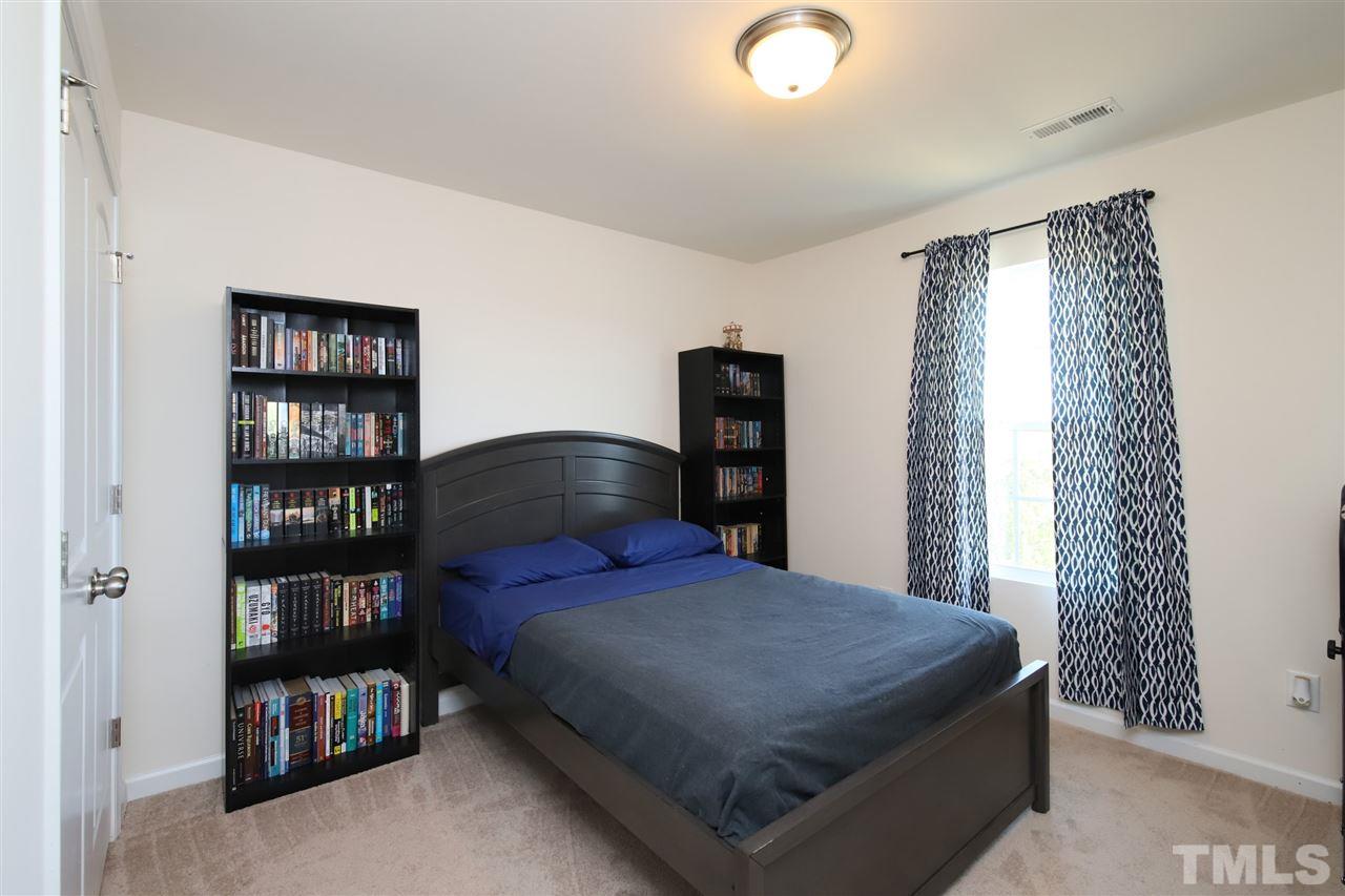 3453 Kernstown Drive Raleigh, NC 27610 - Photo 20 of 21 a bedroom with a bed and a book shelf