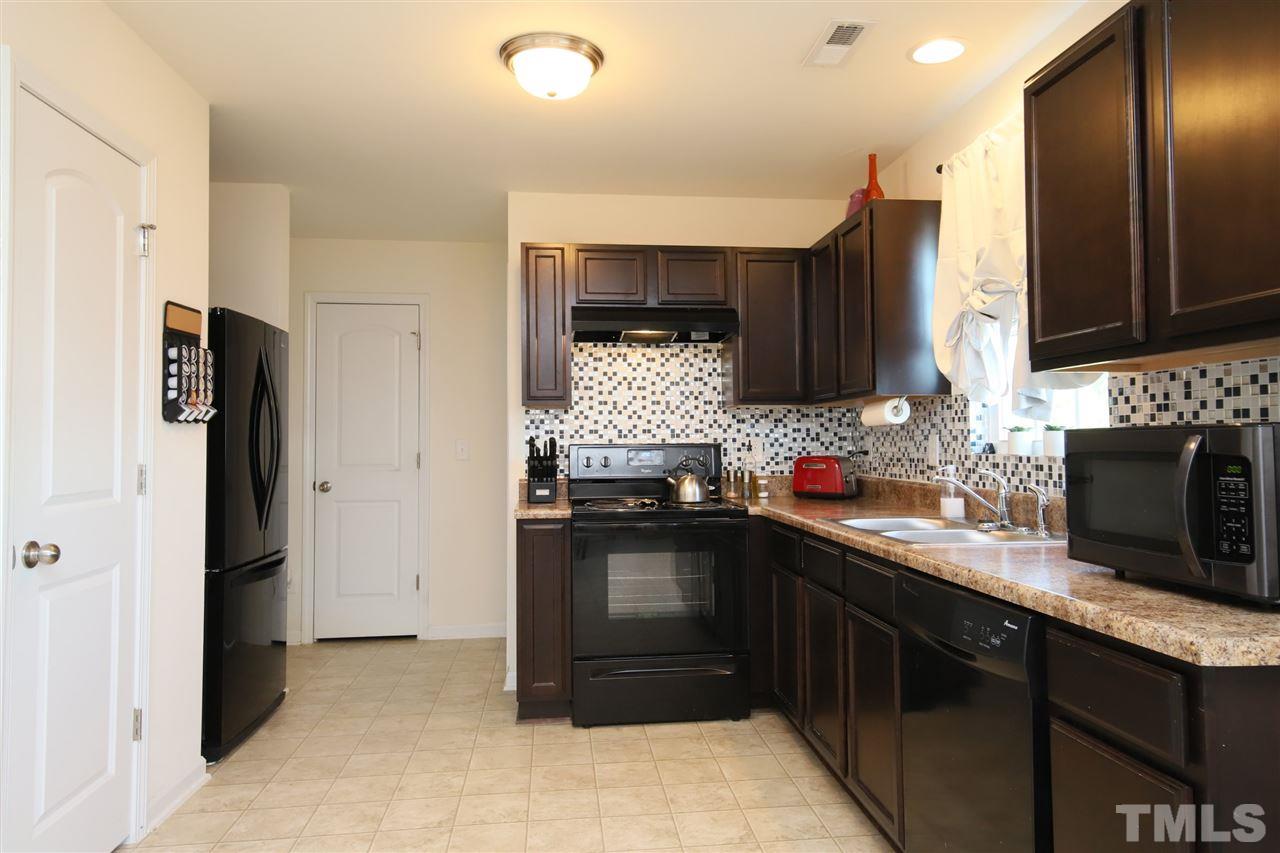 3453 Kernstown Drive Raleigh, NC 27610 - Photo 8 of 21 a kitchen with stainless steel appliances granite countertop a sink stove and refrigerator