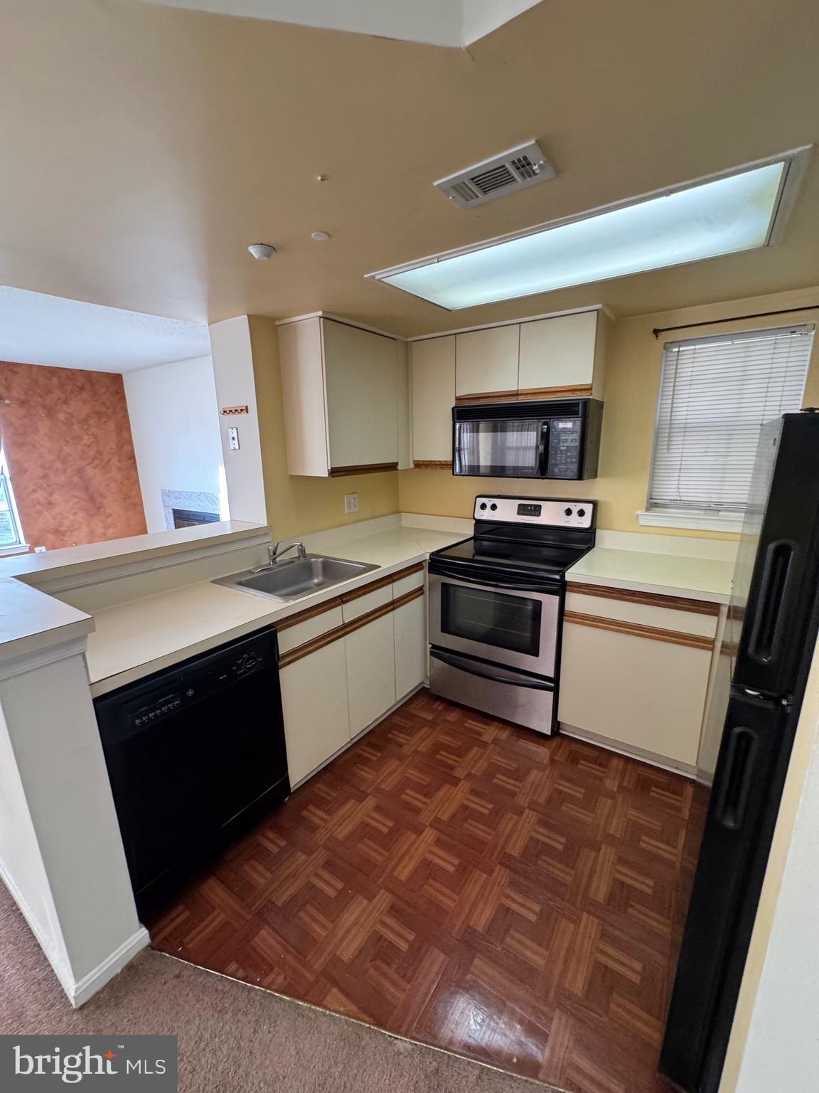 14121 Bowsprit Lane, Unit 301 Laurel, MD 20707 - Photo 5 of 8 a kitchen with a stove a sink and a microwave