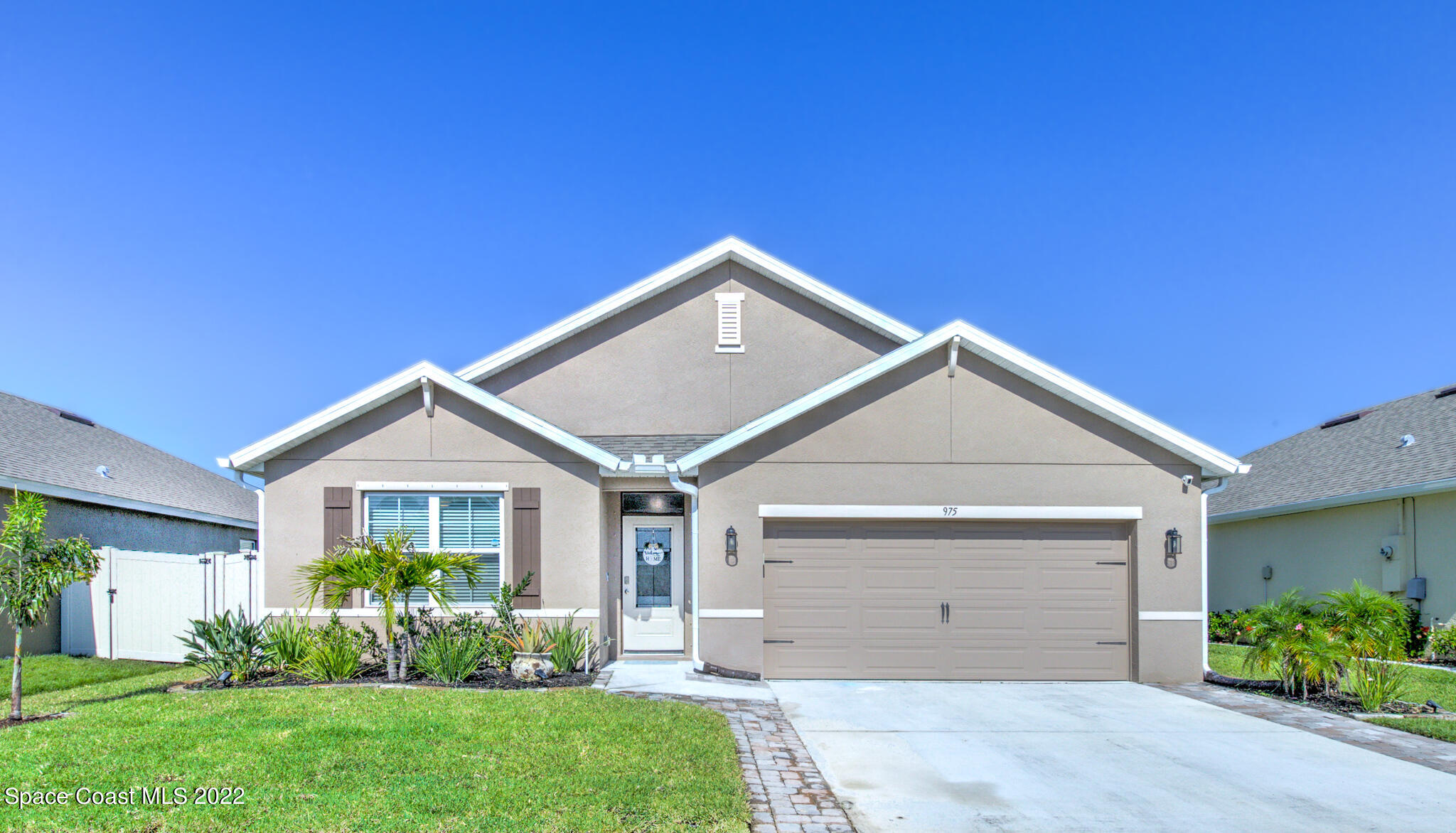 a front view of a house with a garden and plants