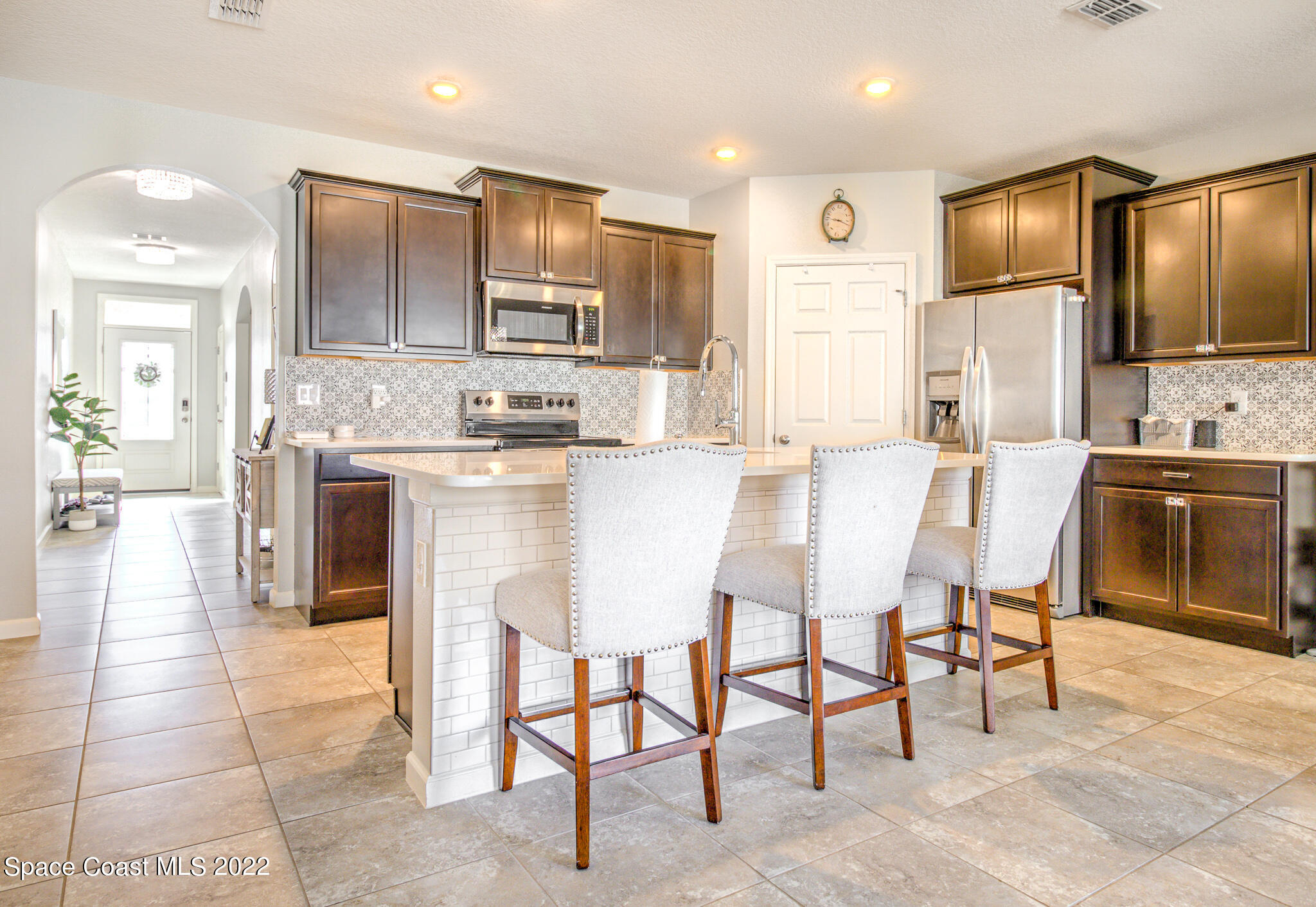 975 Newton Circle Rockledge, FL 32955 - Photo 5 of 30 a kitchen with kitchen island granite countertop wooden cabinets and refrigerator