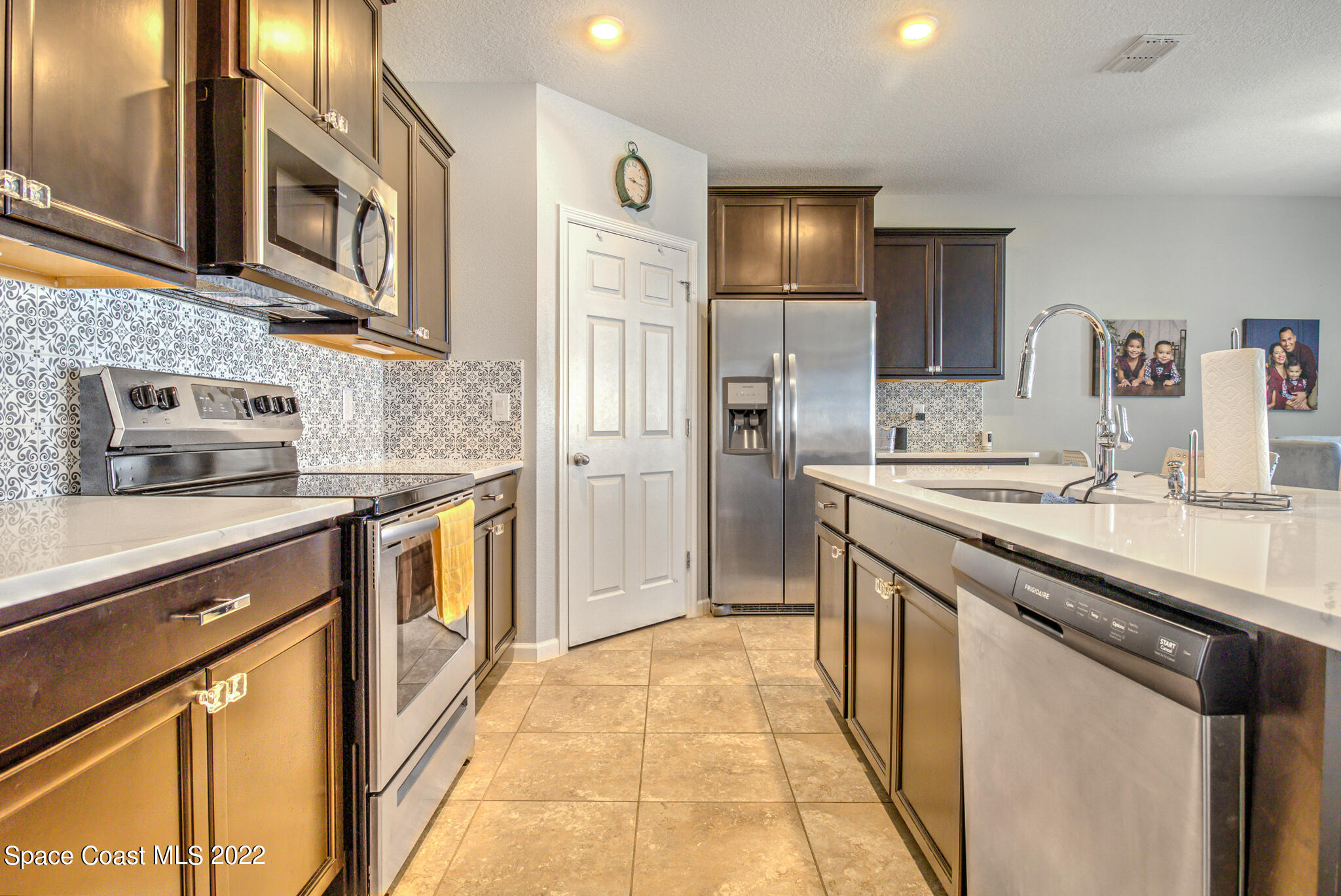 975 Newton Circle Rockledge, FL 32955 - Photo 7 of 30 a kitchen with stainless steel appliances granite countertop a sink and cabinets