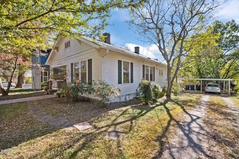 a view of a house with backyard and trees