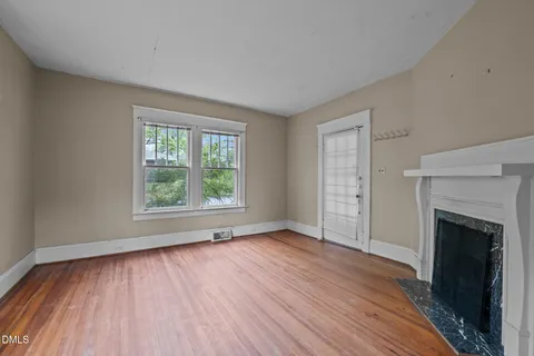 wooden floor fireplace and windows in an empty room