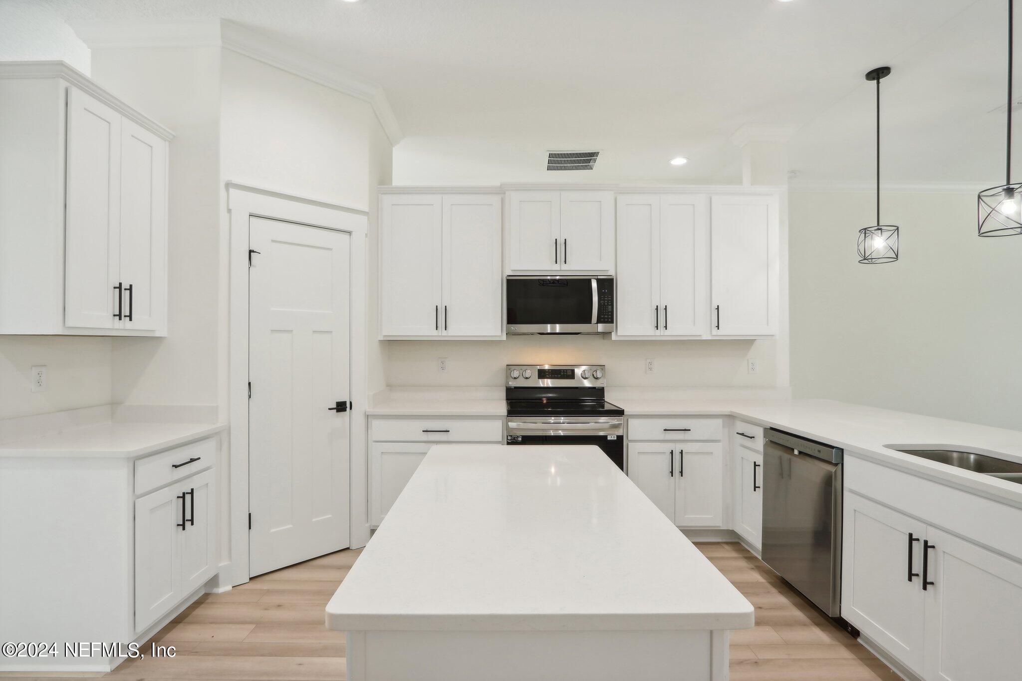 156 Cacique Drive St. Augustine, FL 32086 - Photo 11 of 68 a kitchen with white cabinets and stainless steel appliances