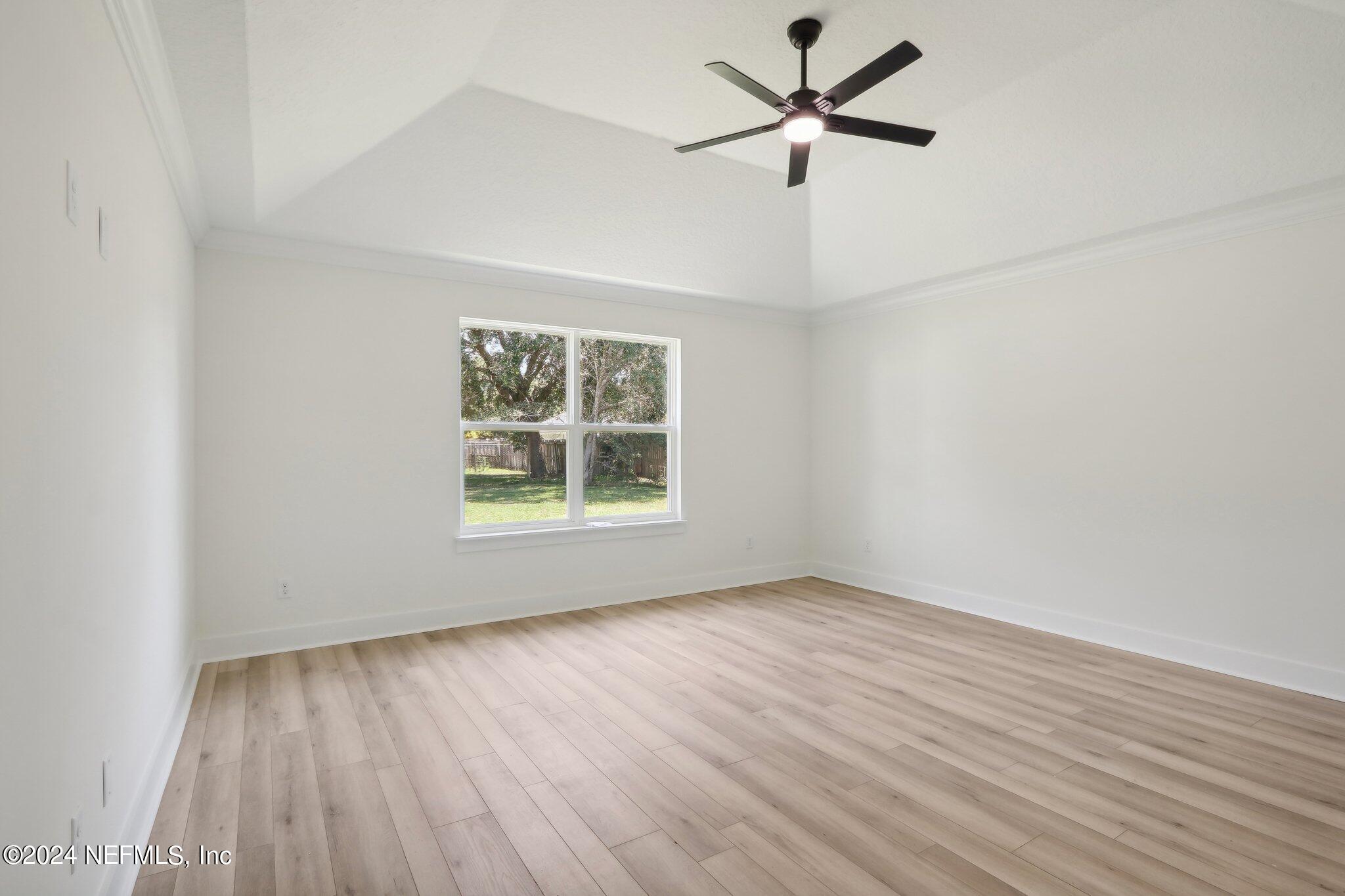 156 Cacique Drive St. Augustine, FL 32086 - Photo 20 of 68 an empty room with wooden floor ceiling fan and window