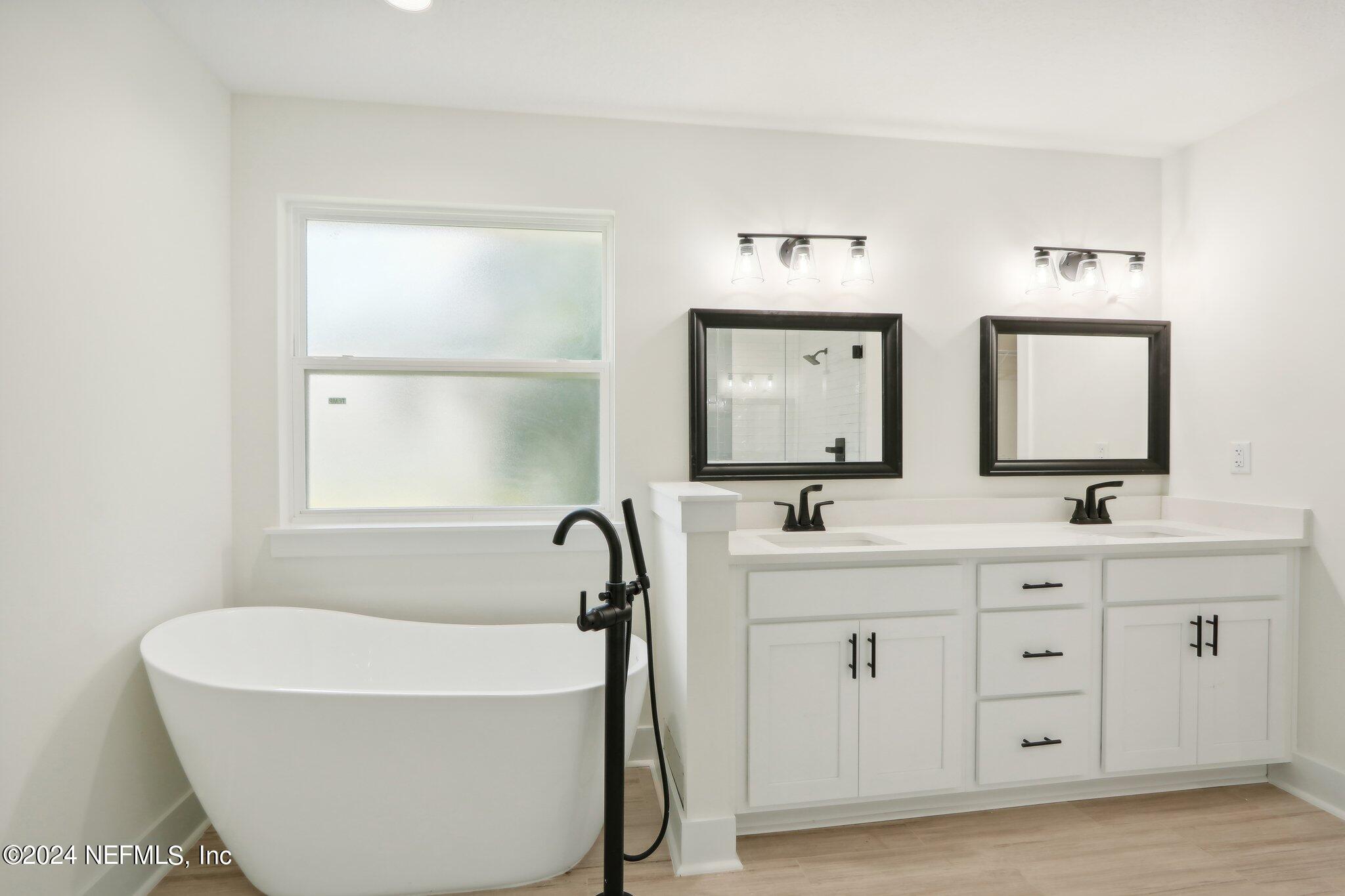 156 Cacique Drive St. Augustine, FL 32086 - Photo 23 of 68 a bathroom with a double vanity sink mirror and bathtub