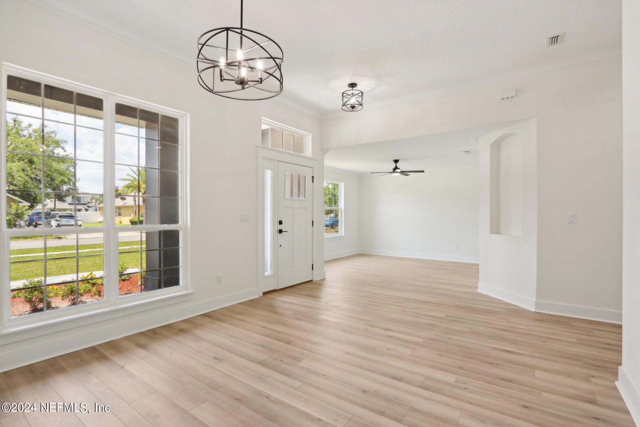 156 Cacique Drive St. Augustine, FL 32086 - Photo 6 of 68 a view of an empty room with wooden floor and a window