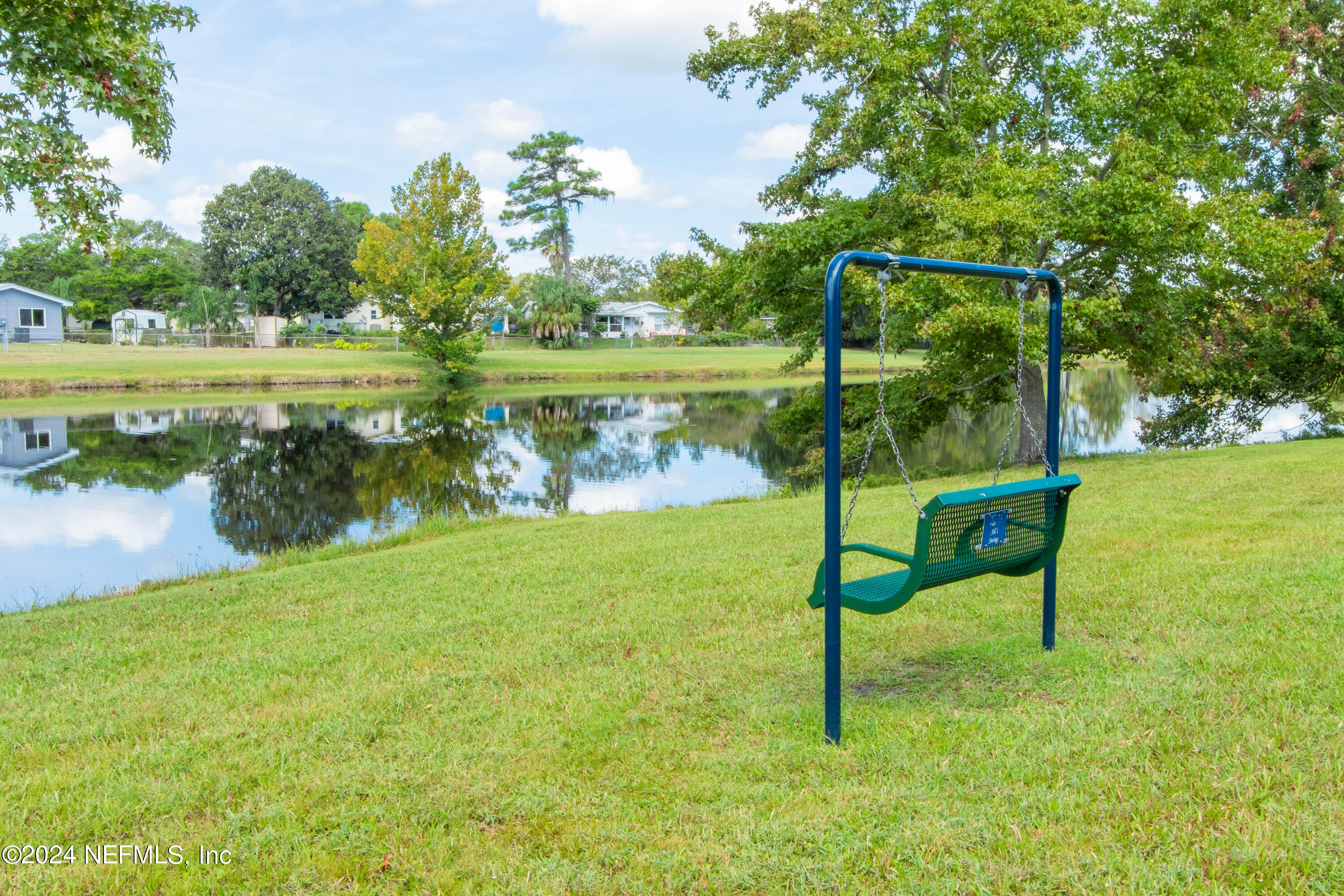 156 Cacique Drive St. Augustine, FL 32086 - Photo 61 of 68 a view of a lake with a bench in the background