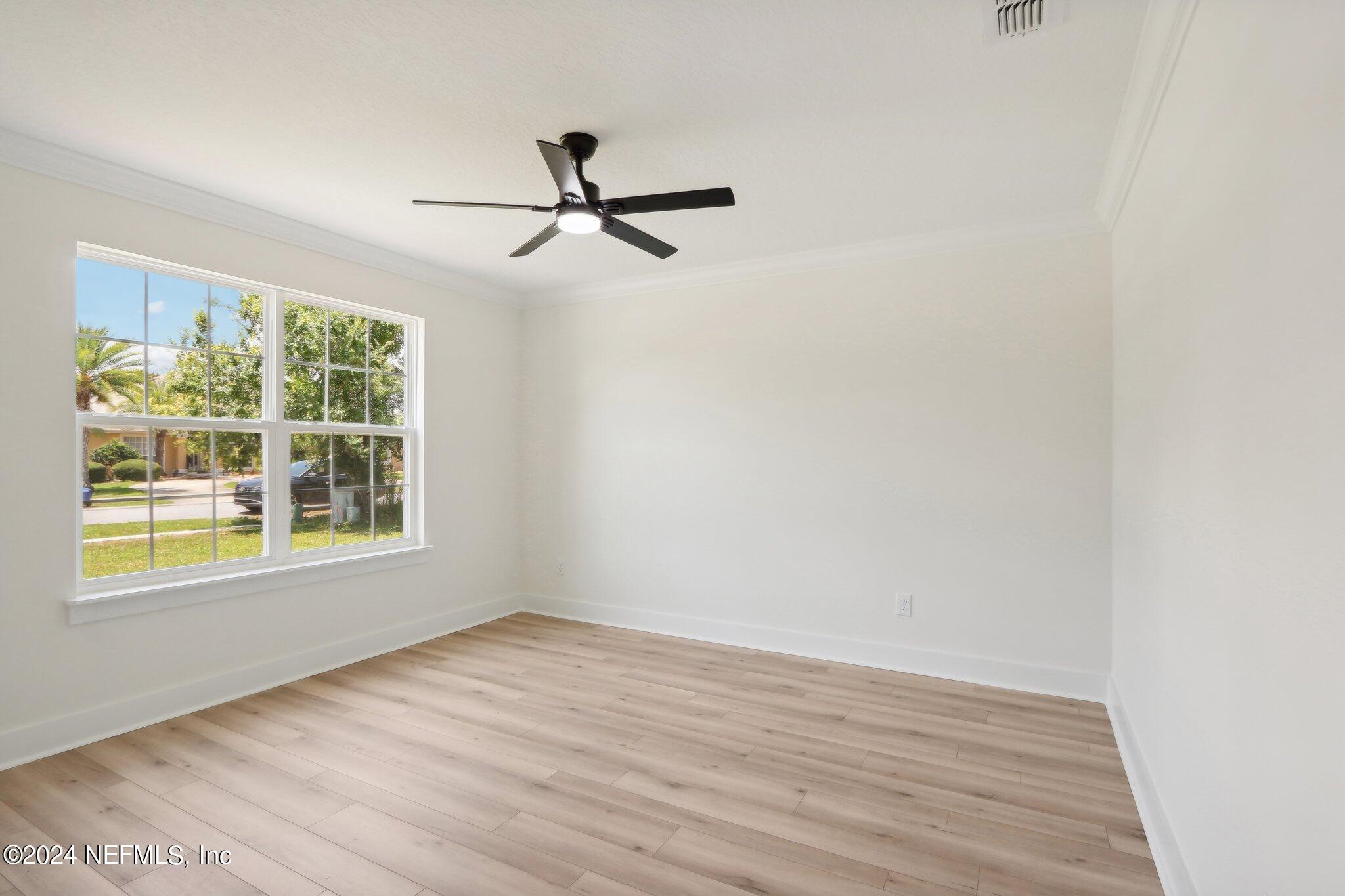156 Cacique Drive St. Augustine, FL 32086 - Photo 7 of 68 a view of an empty room with wooden floor and a window