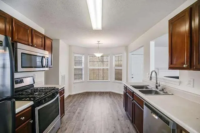 a kitchen with stainless steel appliances granite countertop a stove and a sink