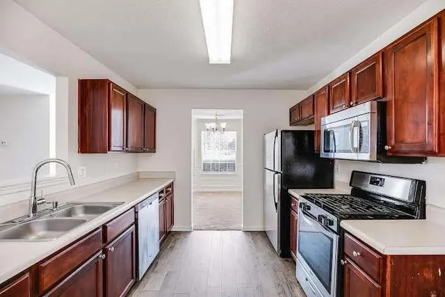 a kitchen with granite countertop a sink stove and refrigerator