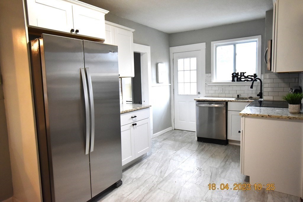 84 Wilton Street Springfield, MA 01109 - Photo 4 of 13 a kitchen with stainless steel appliances granite countertop a refrigerator a sink a stove and island