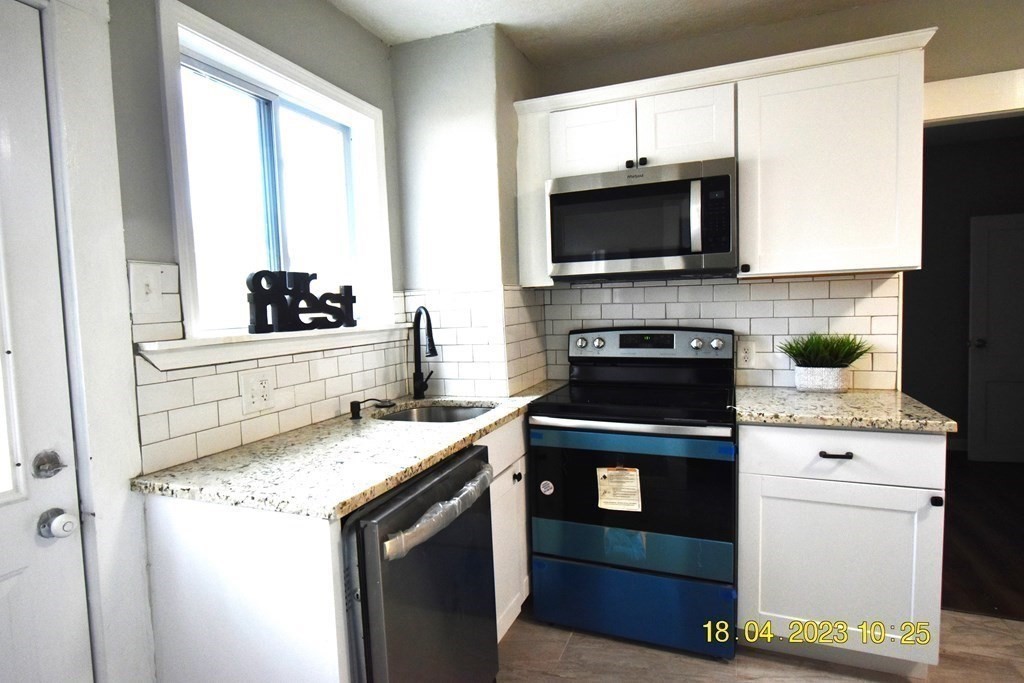 84 Wilton Street Springfield, MA 01109 - Photo 7 of 13 a kitchen with a stove and a microwave