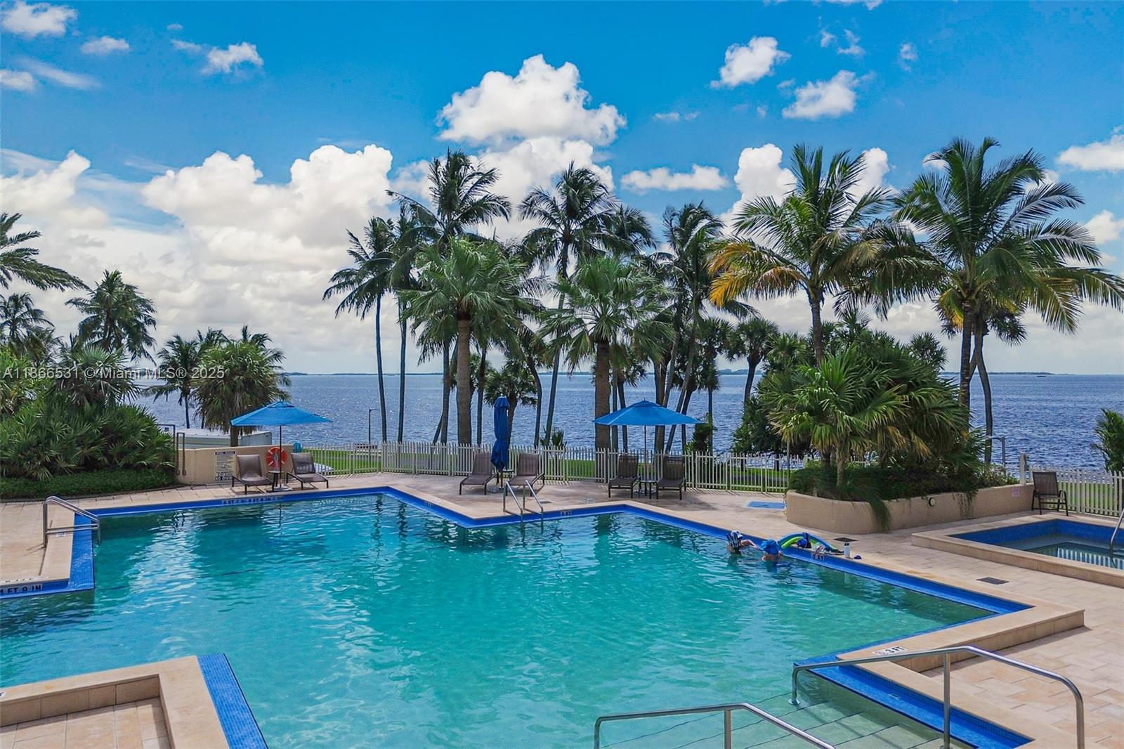2 Grove Isle Drive, Unit B1603 Miami, FL 33133 - Photo 18 of 20 a view of a swimming pool with a table and chairs