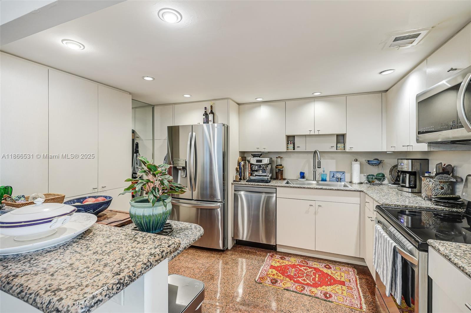 2 Grove Isle Drive, Unit B1603 Miami, FL 33133 - Photo 5 of 20 a kitchen with stainless steel appliances granite countertop a sink stove and refrigerator