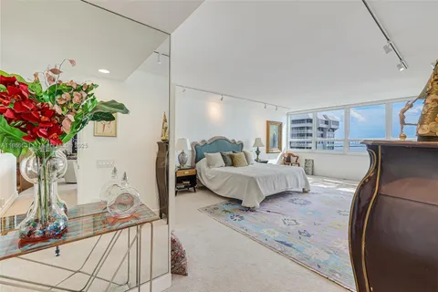 a bedroom with furniture and large windows