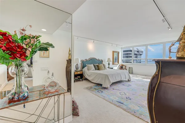 a bedroom with furniture and large windows