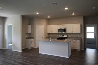 a kitchen with stainless steel appliances granite countertop a stove top oven a sink and a refrigerator