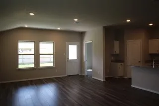 an empty room with wooden floor and a window