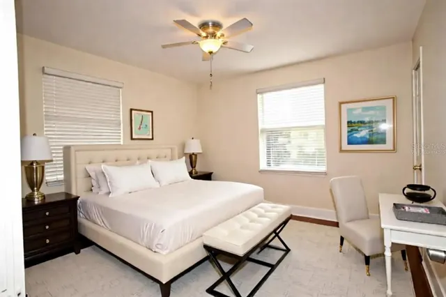 an empty room with wooden floor and ceiling fan
