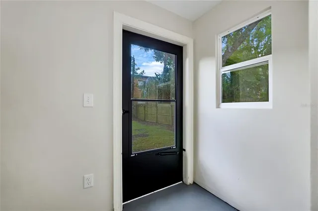 a view of a patio with couches table and chairs under an umbrella with a fire pit