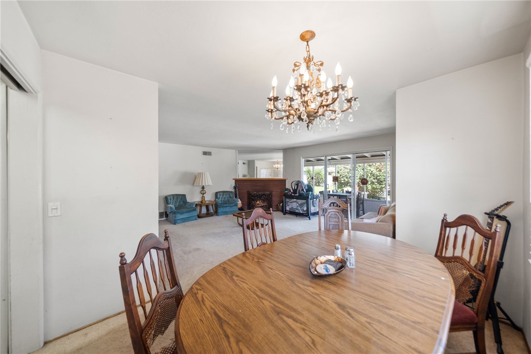 5433 Rochester Street Riverside, CA 92504 - Photo 7 of 29 Dining area opening into the living room, with a chandelier and views toward the covered patio.