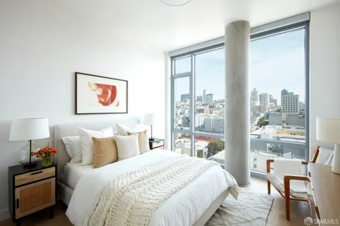 a bedroom with a bed and a large mirror next to a window