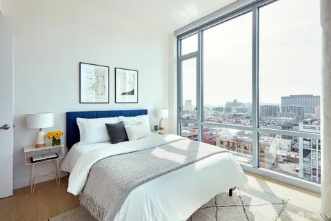 a bedroom with a large window and a bed