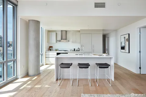 a kitchen with granite countertop a stove a sink and a refrigerator
