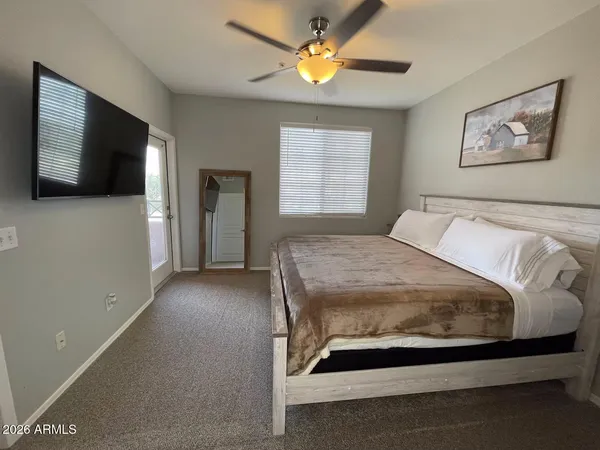 a spacious bedroom with a bed and a flat screen tv