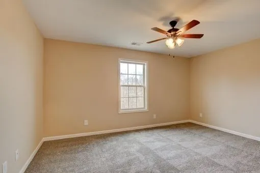 an empty room with windows and ceiling fan