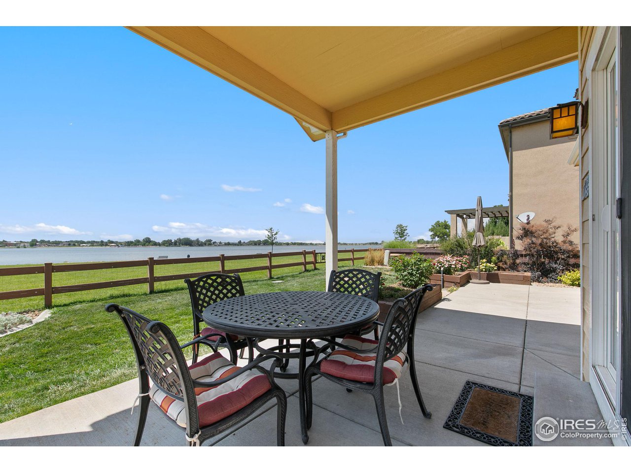 55 Veronica Drive Windsor, CO 80550 - Photo 22 of 24 Beautiful gated yard with remote-controlled awning and lake front property.