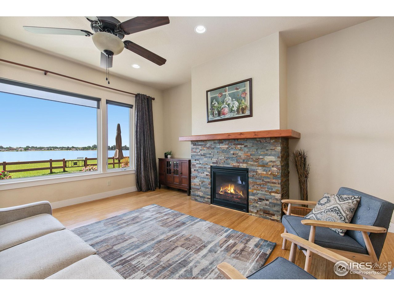 55 Veronica Drive Windsor, CO 80550 - Photo 5 of 24 Living room with AMAZING lake views and comfy fireplace for the winter months.