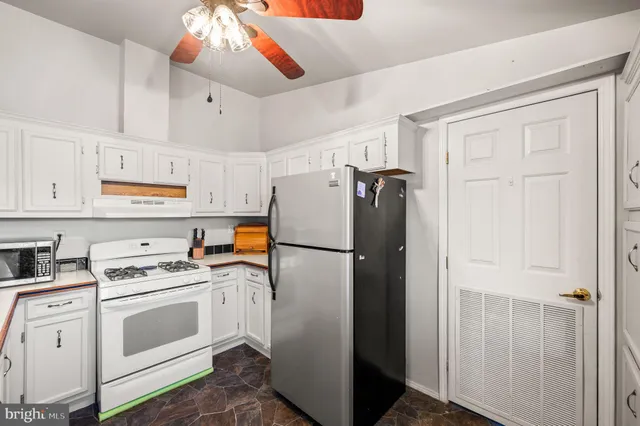 a kitchen with a sink dishwasher and white cabinets