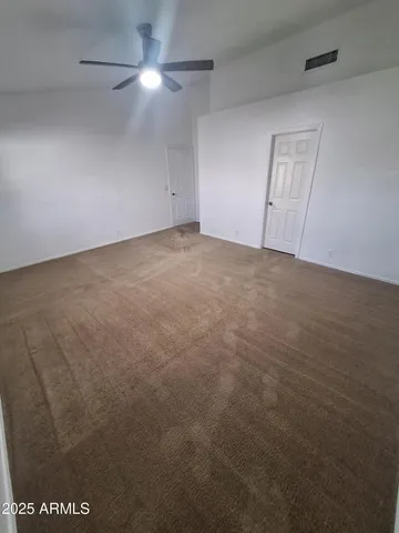 an empty room with windows and fan