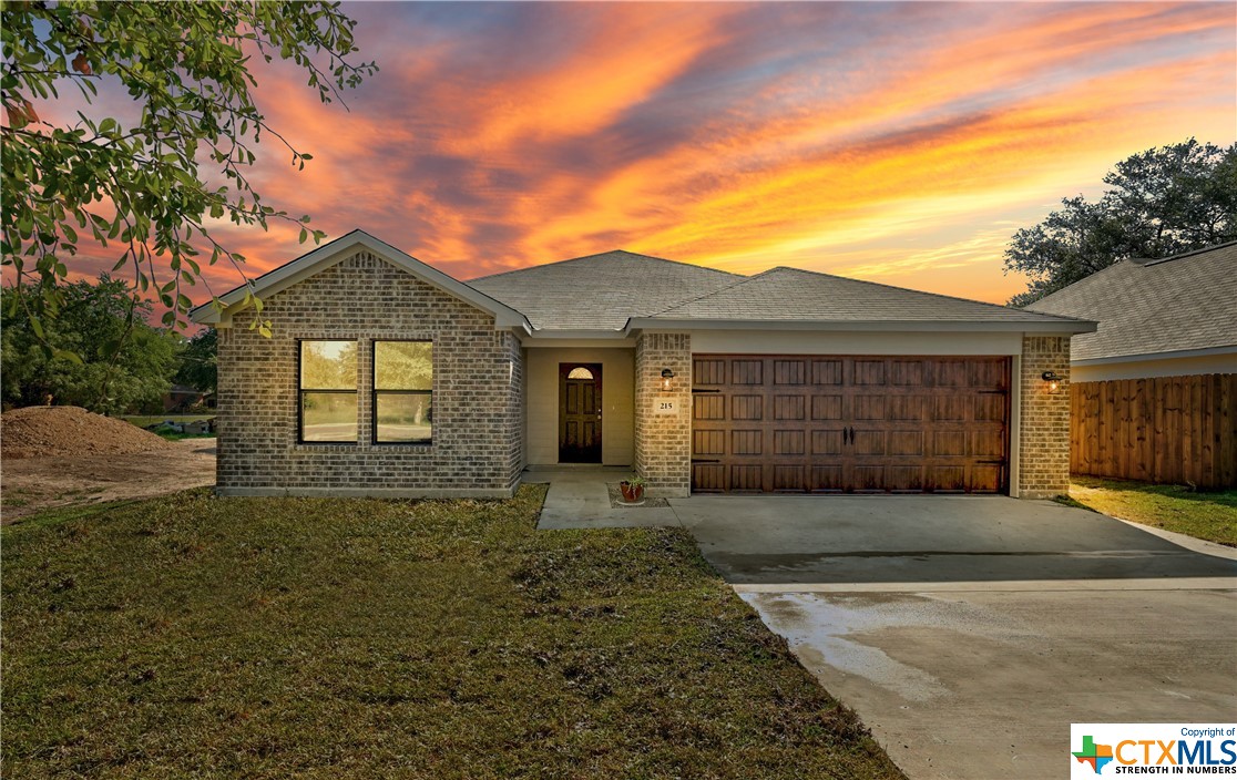 215 Plum Street Luling, TX 78648 - Photo 1 of 27 a front view of a house with a garden