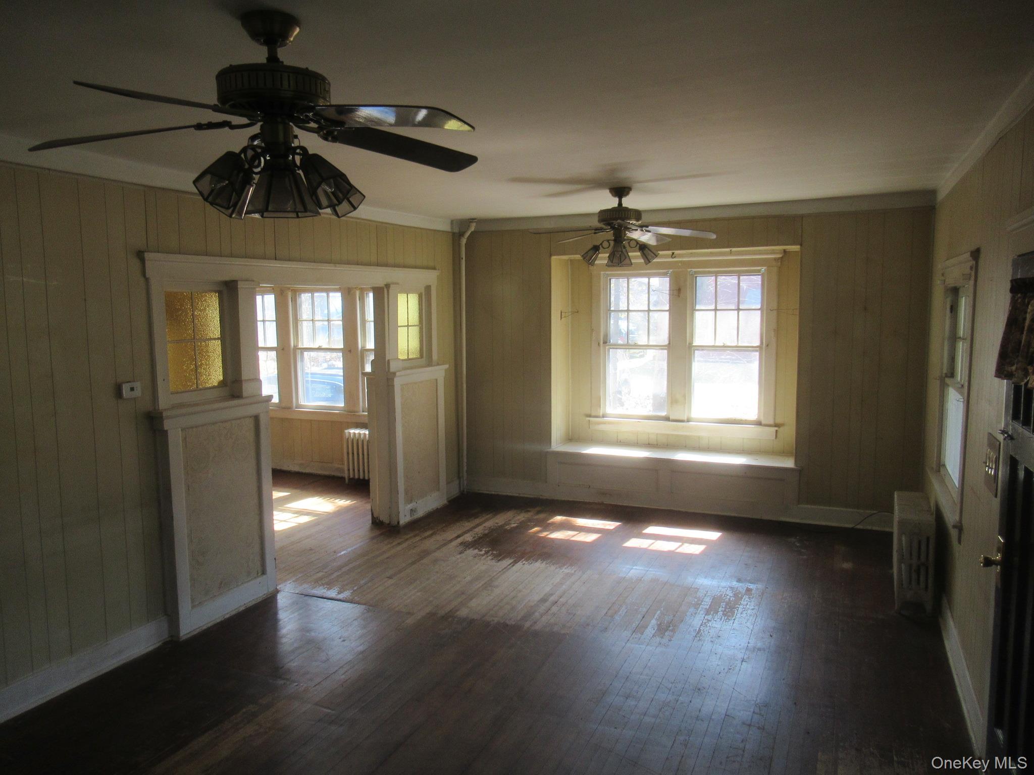 72 Waterstone Road Greenwood Lake, NY 10925 - Photo 13 of 20 Spacious room featuring wood-finish flooring, two ceiling fans with integrated lighting, and multiple windows